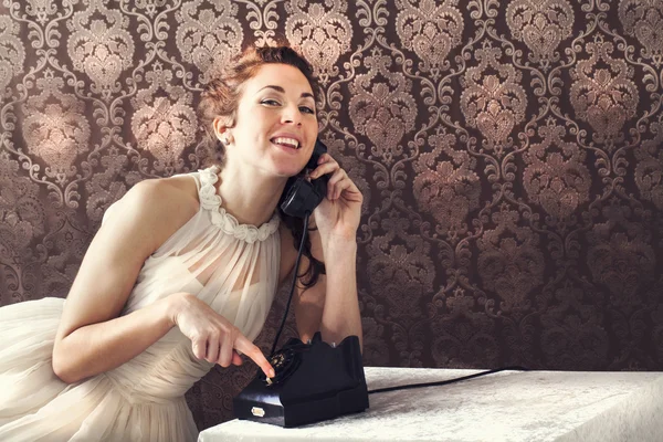 Belle jeune femme au téléphone dans le salon dans son anglais — Photo