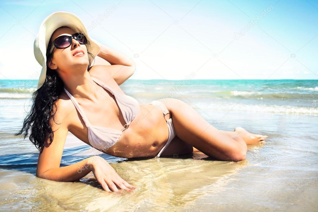 Beautiful girl sunbathing lying in the sea