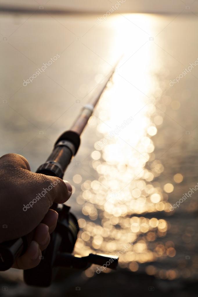 close up of human hand holding fishing-rod