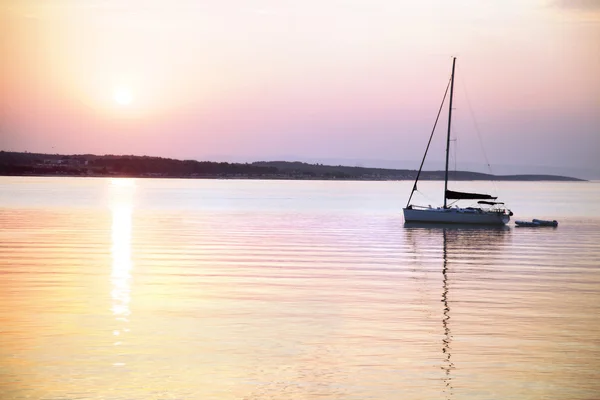 Voilier flotte dans la mer calme au lever du soleil — Photo