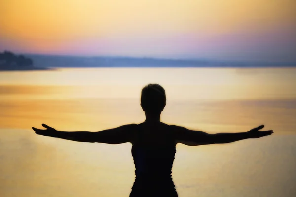 Silhouette einer Frau, die beim Sonnenuntergang tief durchatmet — Stockfoto