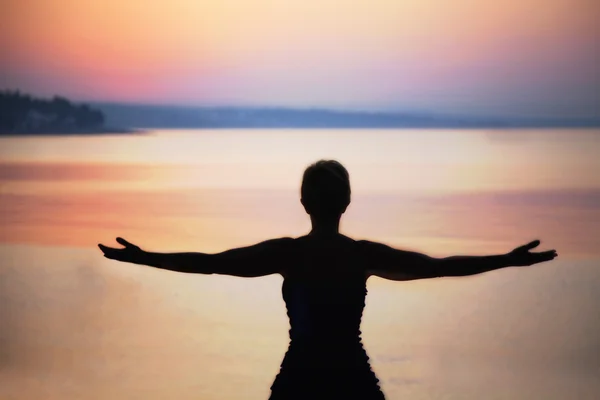 Silhouette of woman taking a deep breath at the sunset — Stock Photo, Image