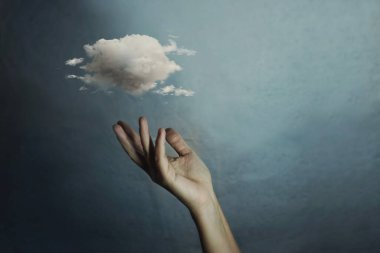 Küçük bir bulutu tutan bir kadının eli