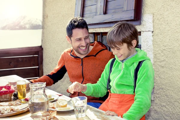Far och son med lunch i en stuga i berget — Stockfoto