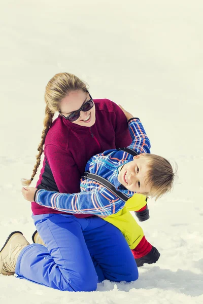 Mutter umarmt ihren Sohn im Schnee — Stockfoto