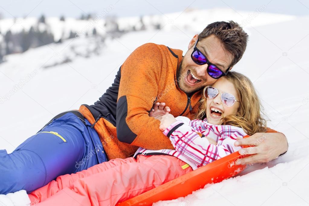 girl and his father sledding very fast
