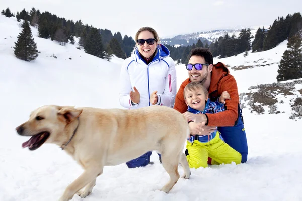 Famille avec chien s'amuser dans la neige — Photo