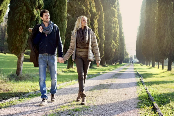 Pareja caminando en la frondosa avenida en un día de otoño — Foto de Stock