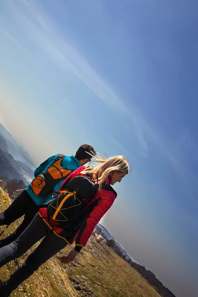 Casal de caminhantes andando nas montanhas respirando ar limpo — Fotografia de Stock