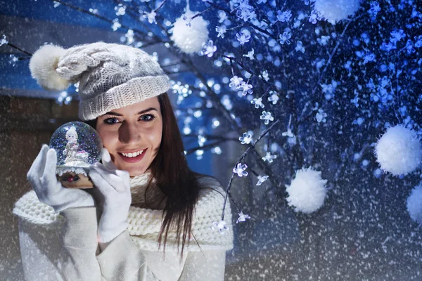 Güzel kadın gülümsüyor ve onun Boule de neige gösterir — Stok fotoğraf