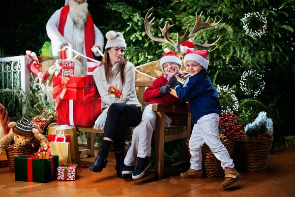 Dwa małe Santa klauzule podnosząc prezent — Zdjęcie stockowe