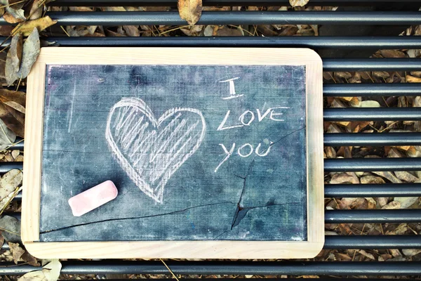 En kjærlighetsbeskjed lagt igjen på en benk på Valentinsdagen – stockfoto