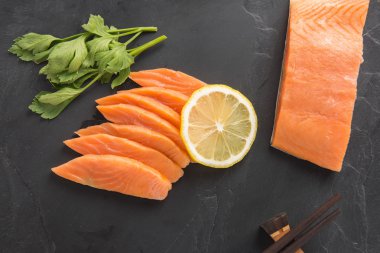 Siyah arka plan üzerine limonlu taze somon