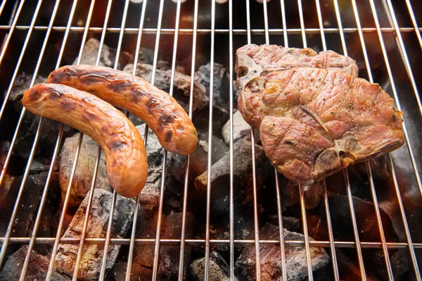 Grillwürste und Fleisch auf dem Grill — Stockfoto