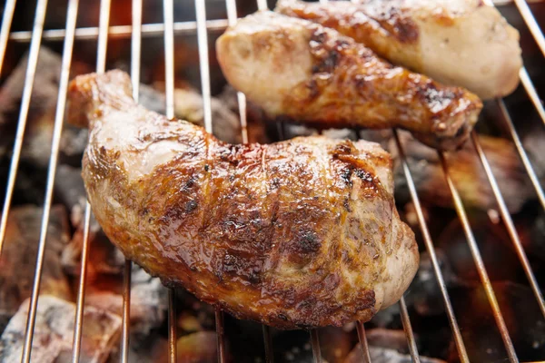 Coxa de frango grelhada sobre chamas em um churrasco — Fotografia de Stock