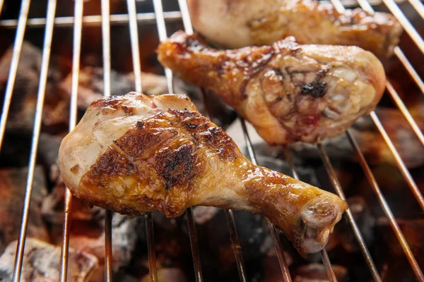 Grilled chicken drumstick over flames on a barbecue — Stock Photo, Image