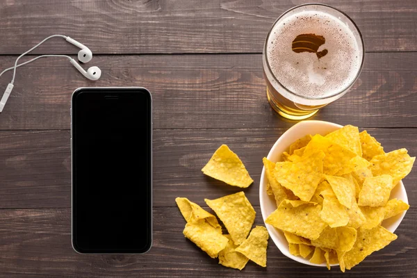 Glas bier met nachos chips op een houten achtergrond — Stockfoto