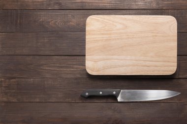 Bıçak ve kesme tahtası ahşap arka plan üzerinde