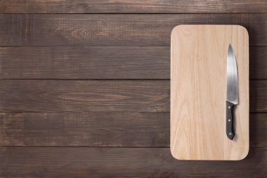 Bıçak ve kesme tahtası ahşap arka plan üzerinde