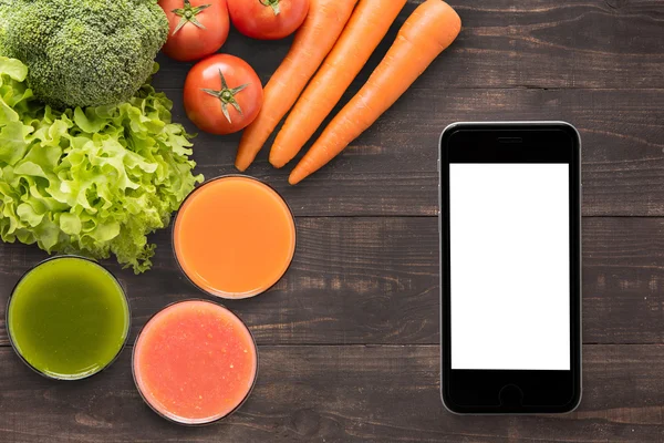 Gemüsesäfte und Smoothie auf Holzgrund mit smartpho — Stockfoto