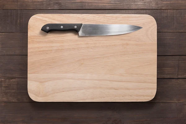 Cuchillo y tabla de cortar en el fondo de madera —  Fotos de Stock