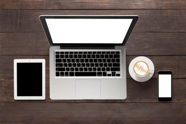 Dizüstü bilgisayar, tablet, smartphone ve bir fincan kahve ahşap backgro üzerinde