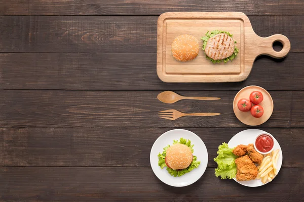 Concept eten hamburgers, gebakken kip, frietjes en tomaat op — Stockfoto