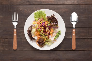 Kaşık ve çatal ahşap masa üzerinde taze salata