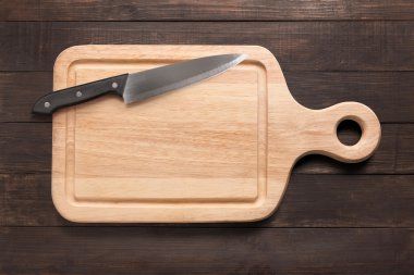 Bıçak ve kesme tahtası ahşap arka plan üzerinde