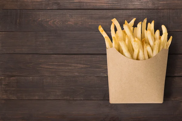 Pommes frites på trä bakgrund. Ovanifrån — Stockfoto