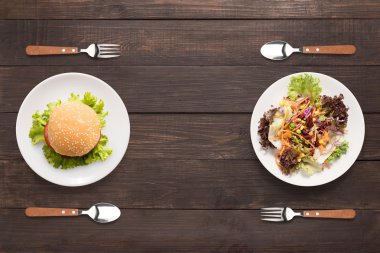 Taze salata ve burger ahşap arka plan üzerinde. zıt foo