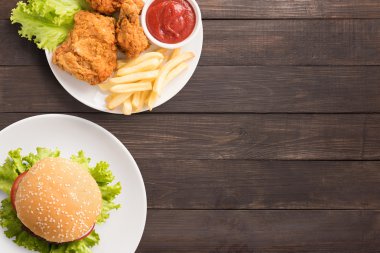 Fast food kızarmış tavuk, patates kızartması ve hamburger üzerinde ahşap ayarla