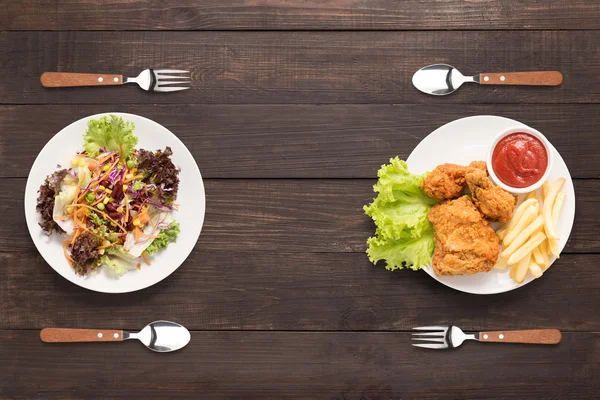 Taze salata ve kızarmış tavuk ve patates kızartması ahşap bac üzerinde