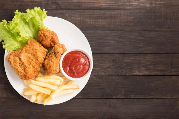 Kızarmış tavuk, ketçap ve kişiler üzerine ahşap arka plan. Fast food
