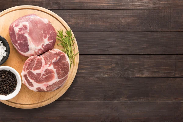 Top view raw pork chop steak and garlic, pepper on wooden backgr — Stock Photo, Image