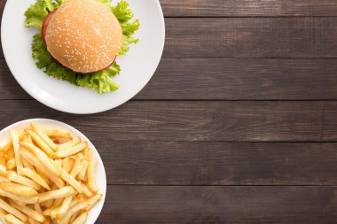 Üstten Görünüm Barbekü hamburger ve kızarmış patates ahşap arka plan üzerinde