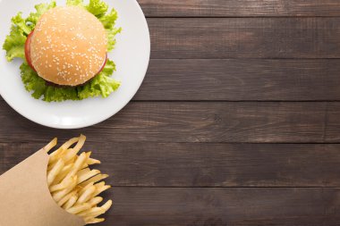Üstten Görünüm Barbekü hamburger ve kızarmış patates ahşap arka plan üzerinde