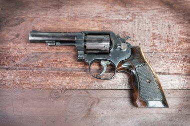siyah tabanca silah üzerinde ahşap arka plan izole mermi ile
