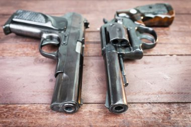 Siyah tabanca tüfek ve yarı otomatik 9 mm top ahşap backgrou