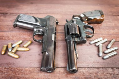 Siyah tabanca tüfek ve yarı otomatik 9 mm top ahşap backgrou