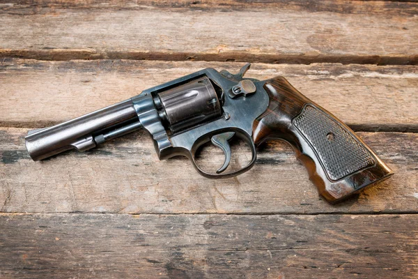 Pistola revolver nera con proiettili isolati su sfondo di legno — Foto Stock