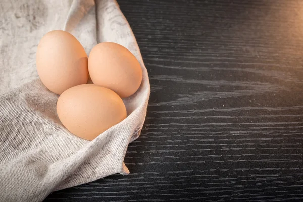 Kip bruin eieren in rouwgewaad op houten achtergrond — Stockfoto