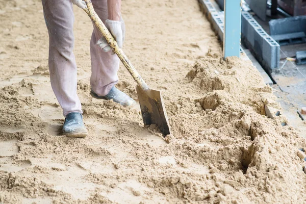 Mann gräbt sich mit Schaufel und Spaten in die Erde — Stockfoto