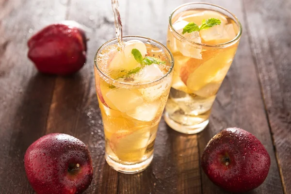 Apple juice pouring from red apples fruits into a glass — Stock Photo, Image