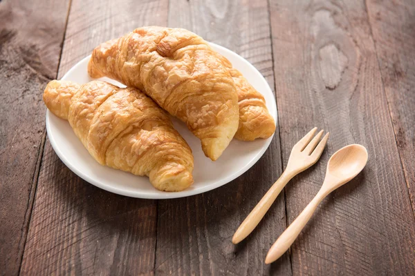 Croissant segar dipanggang di meja kayu — Stok Foto