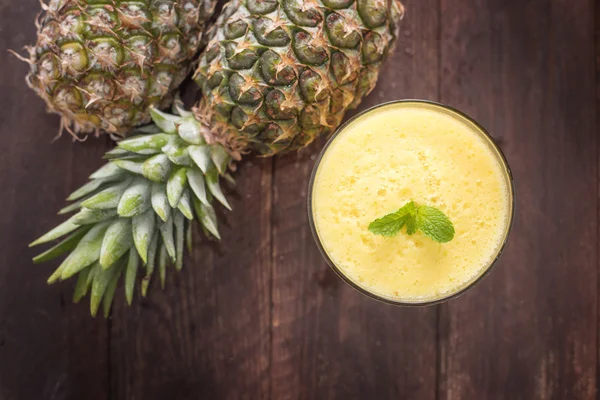 Top pineapple smoothie on wooden table — Stock Photo, Image