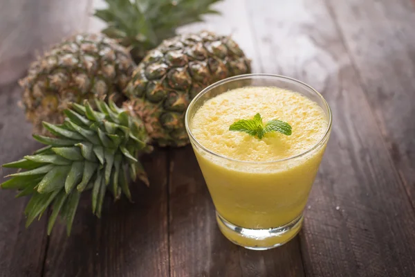 Pineapple smoothie on wooden table — Stock Photo, Image