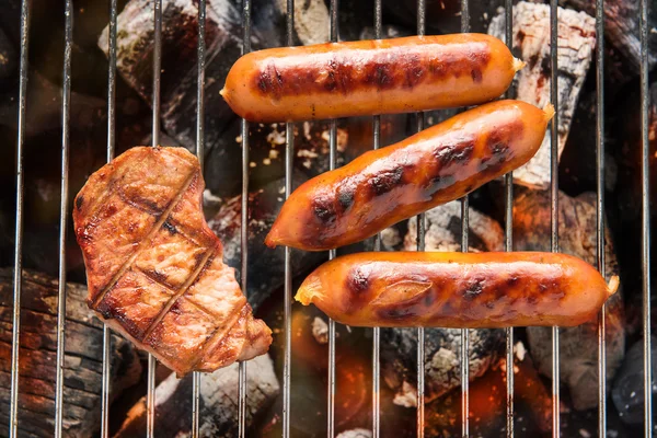 Salchichas BBQ y carne en la parrilla . — Foto de Stock