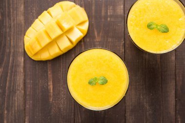 Üst mango smoothie ahşap masaya vurdu.