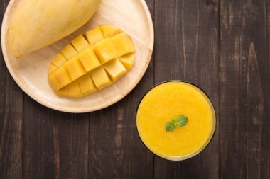 Üst mango smoothie ahşap masaya vurdu.
